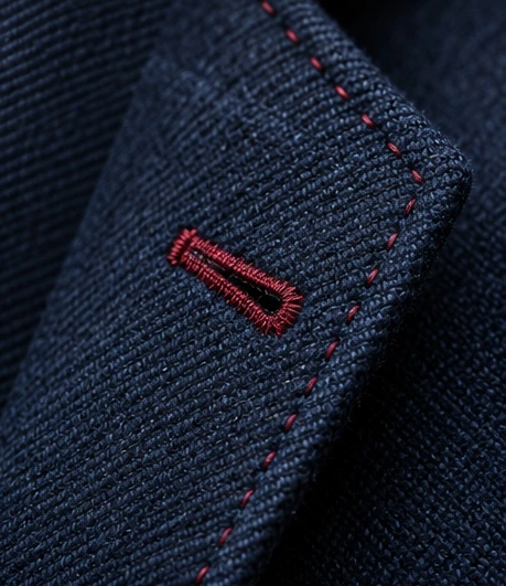 Navy wool lapel with a burgundy buttonhole and stitching